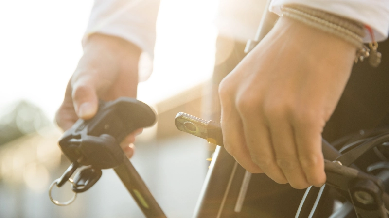 Eine Detailaufnahme eines Radfahrers, der sein Fahrradschloss schließt