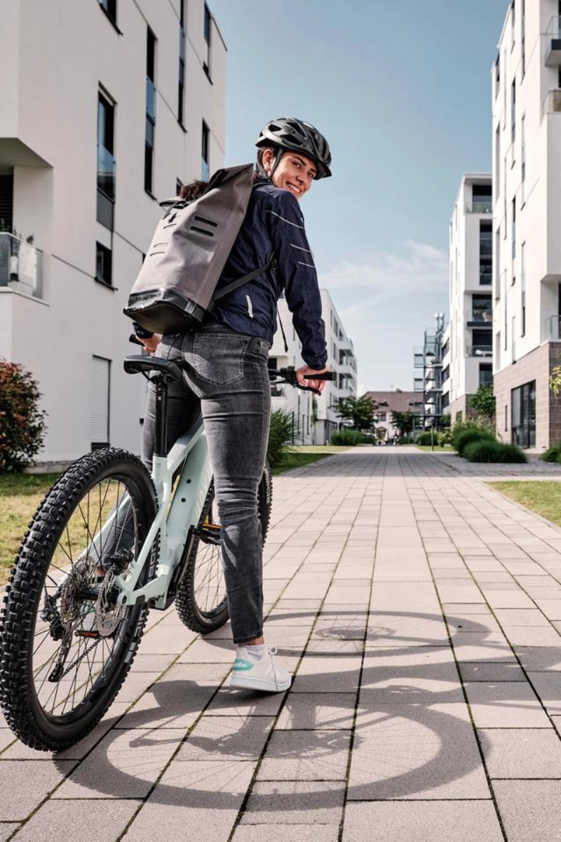 Eine JobRadlerin mit Mountainbike in einer Häuserschlucht