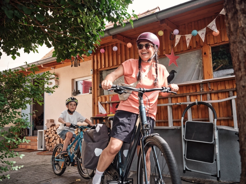 Frau und Kind fahren mit Follow-Me Kupplung zuhause los