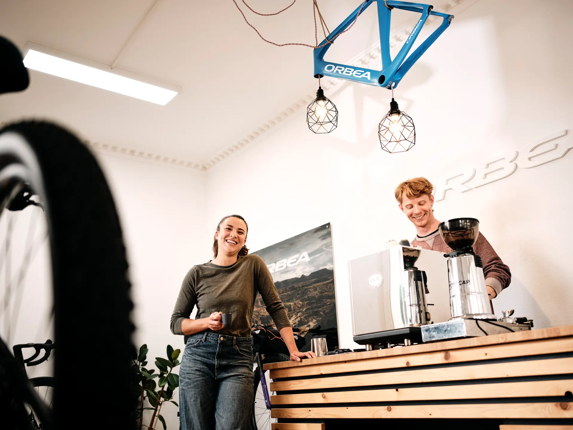 Fachhändlerin im Fahradladen an der Theke mit Espresso
