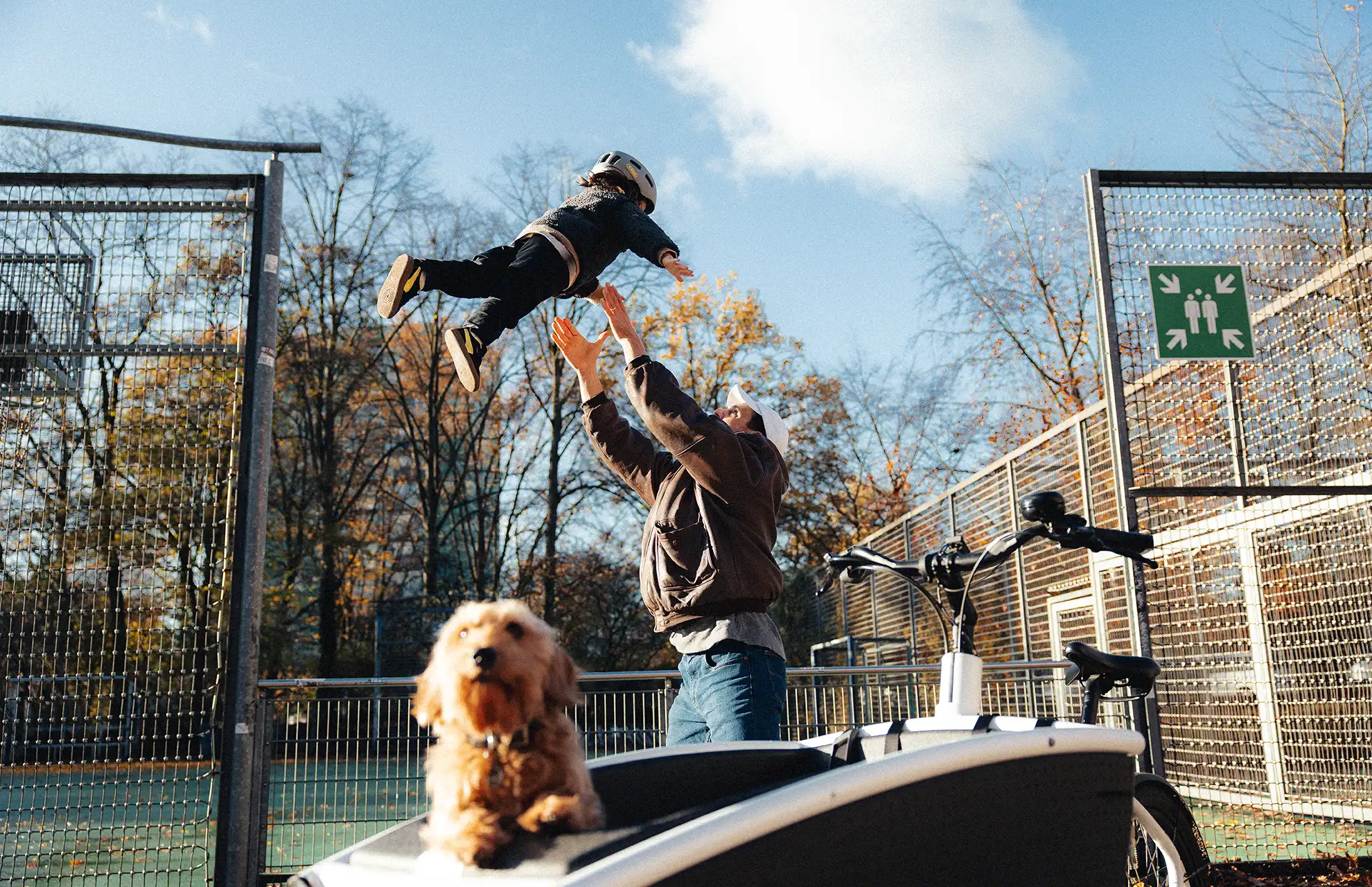 Ein Hund im Leasing-Lastenrad von JobRad und ein Vater mit seinem Kind.