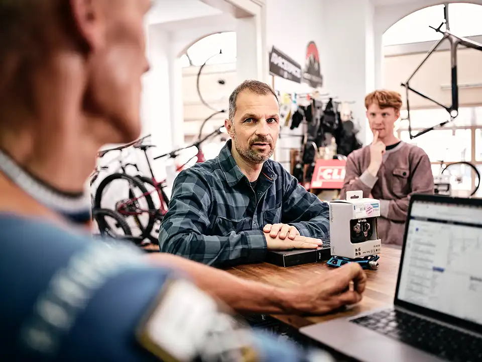 Im Fahrradstore: Fachhändler wirbt Arbeitgeber für JobRad, im Hintergrund ein weierer Mitarbeiter
